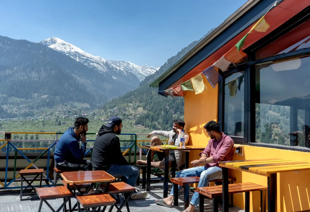 People sitting in open cafe with hill view
