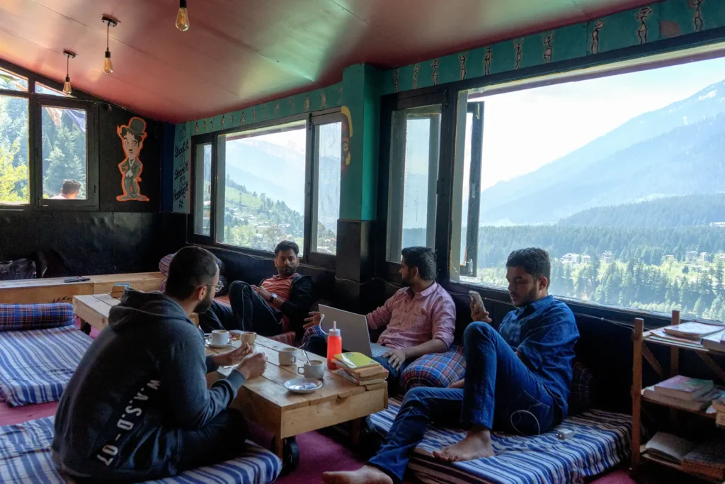 People sitting in a cafe with hill view windows